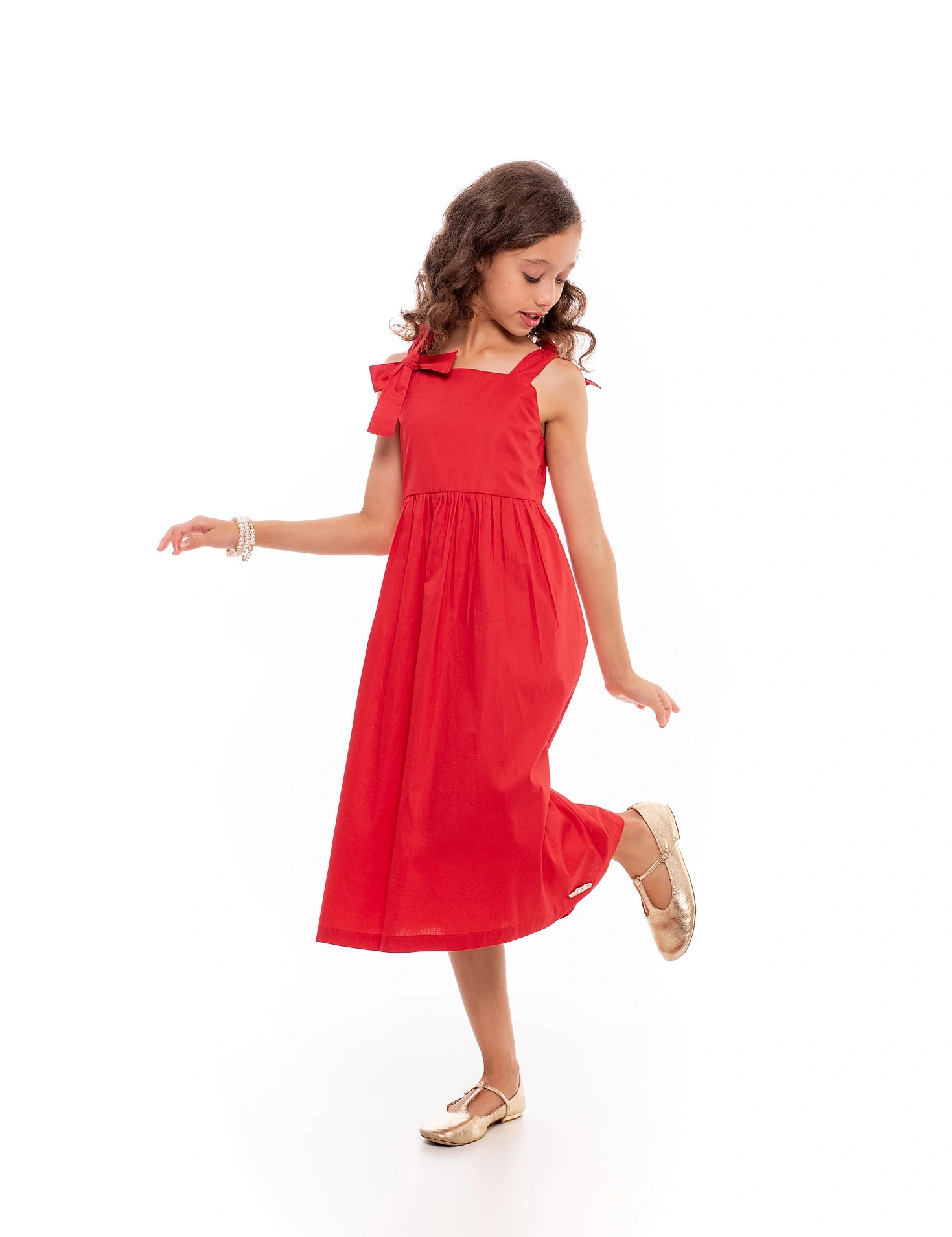 Vestido midi feminino infantil com alças largas e laços, saia ampla e tecido macio.
