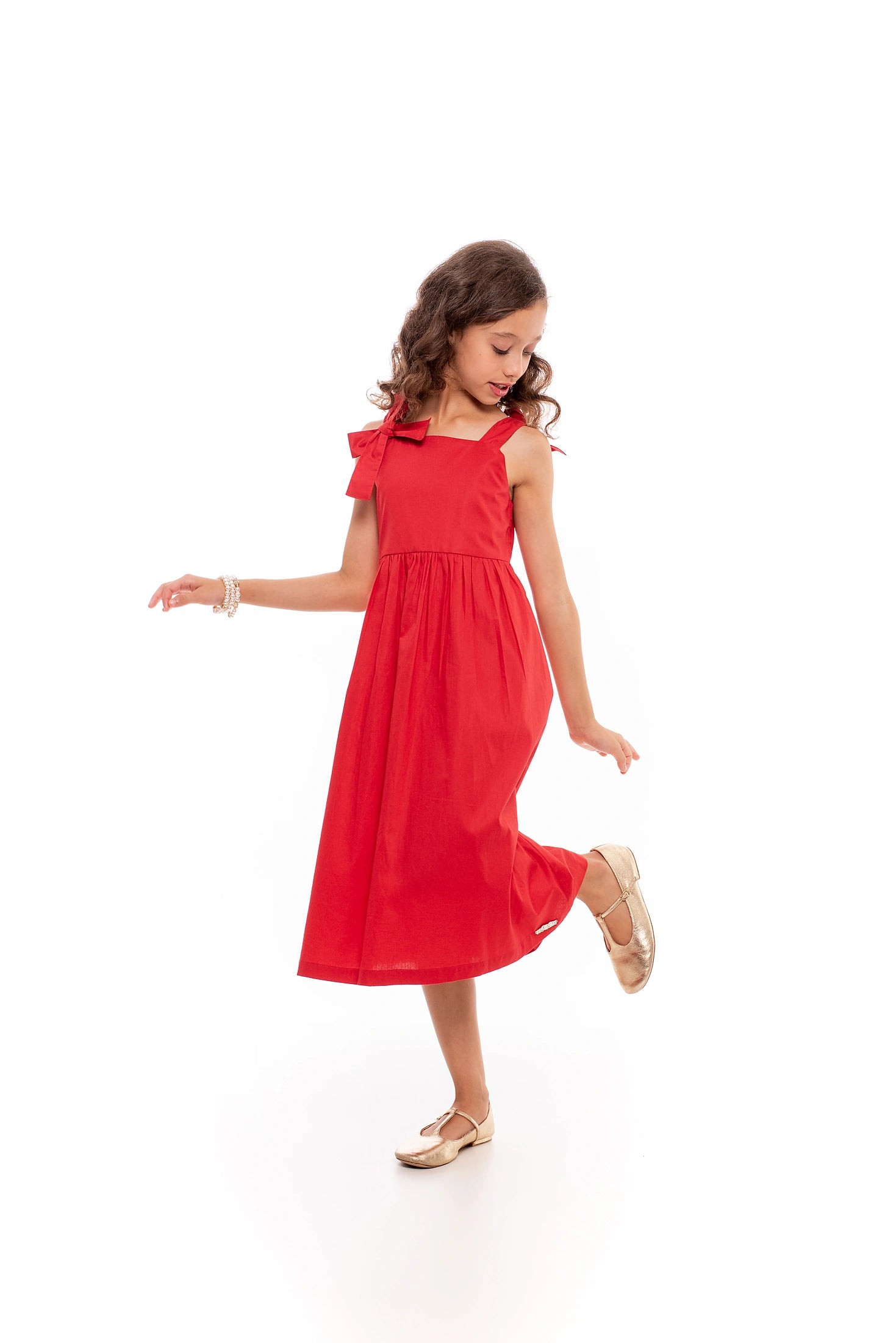 Vestido midi feminino infantil com alças largas e laços, saia ampla e tecido macio.