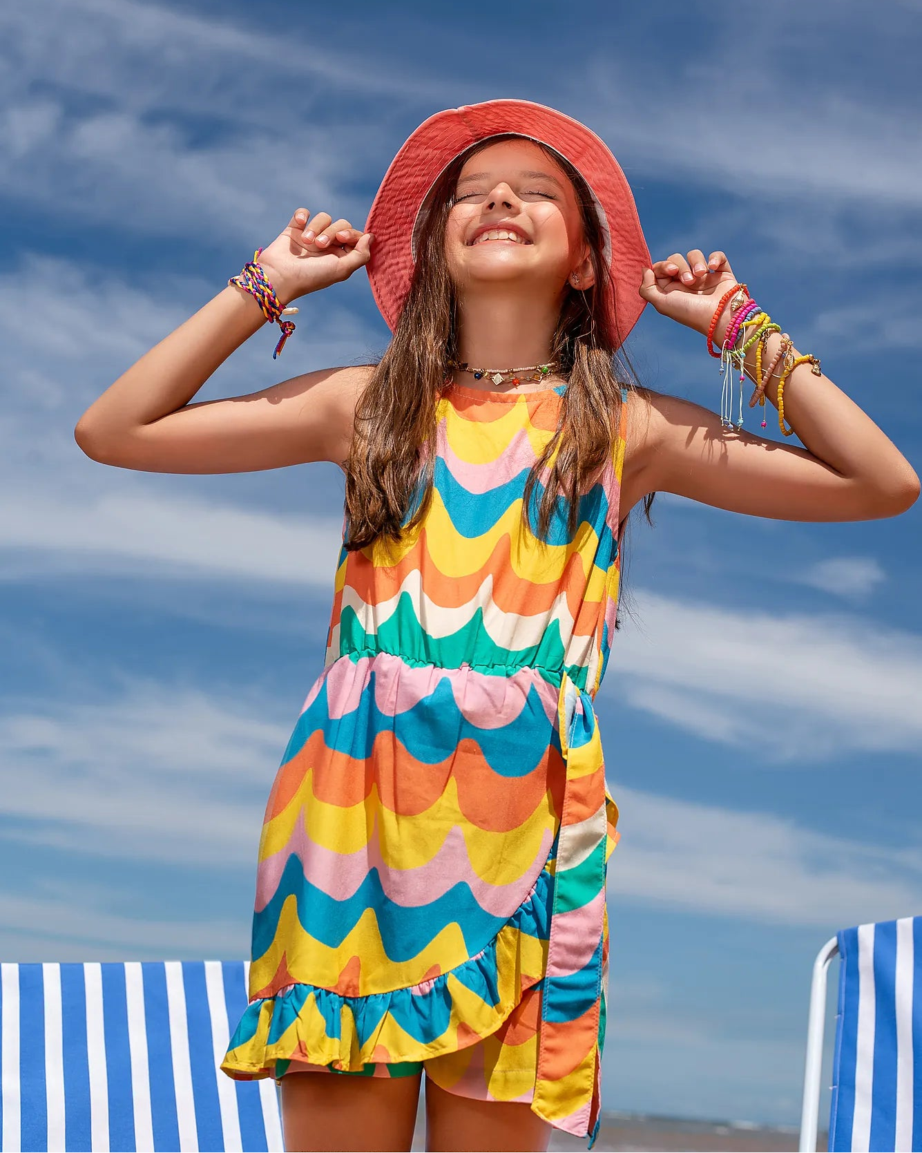 Macacão infantil feminino com estampa de ondas coloridas e saia com babados