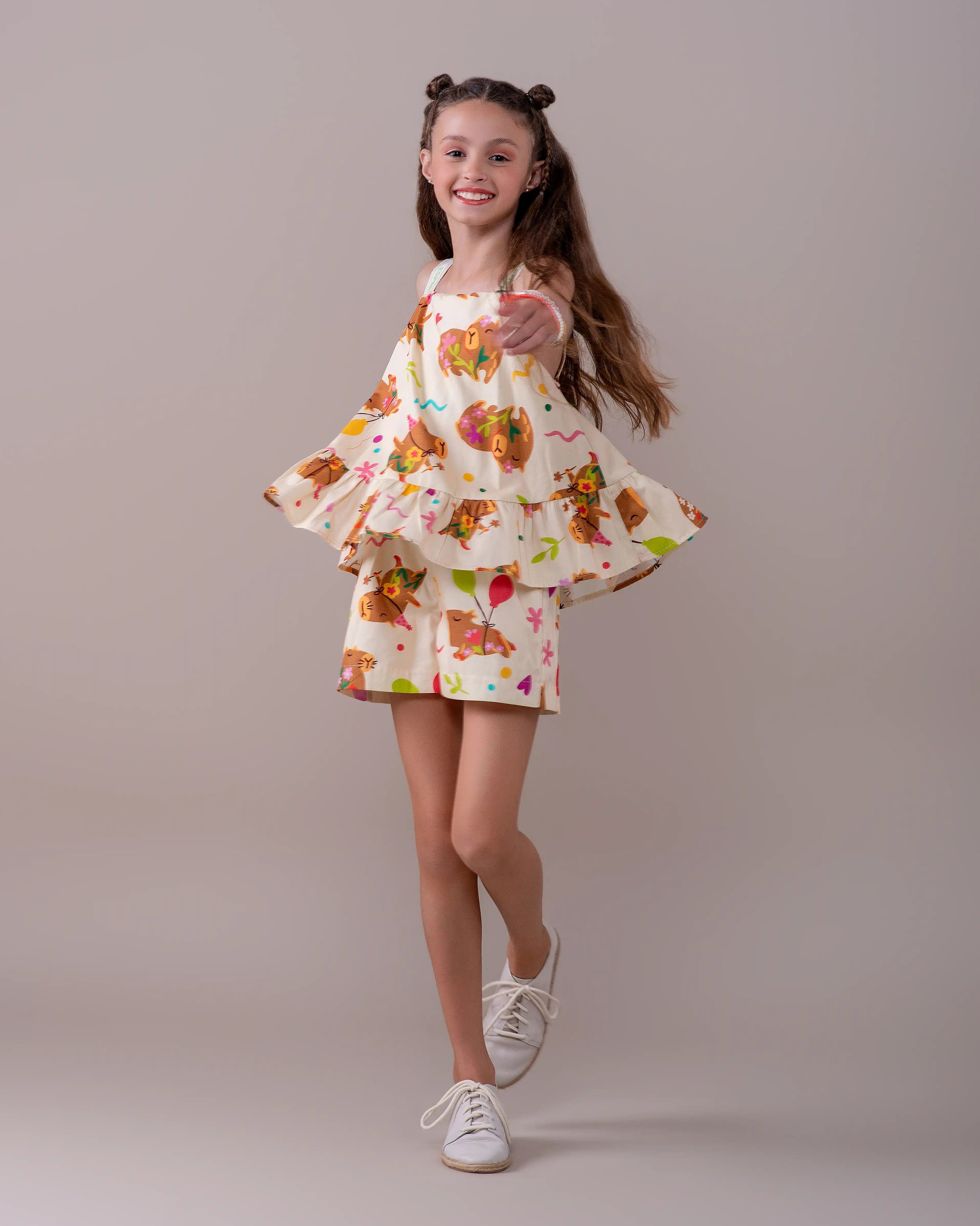 Macacão infantil com estampa de capivaras e flores, alças largas e camadas na parte inferior