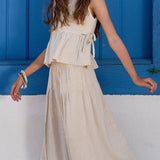 Conjunto feminino infantil com blusa de alças largas e calças amplas em tom claro, detalhe de amarração