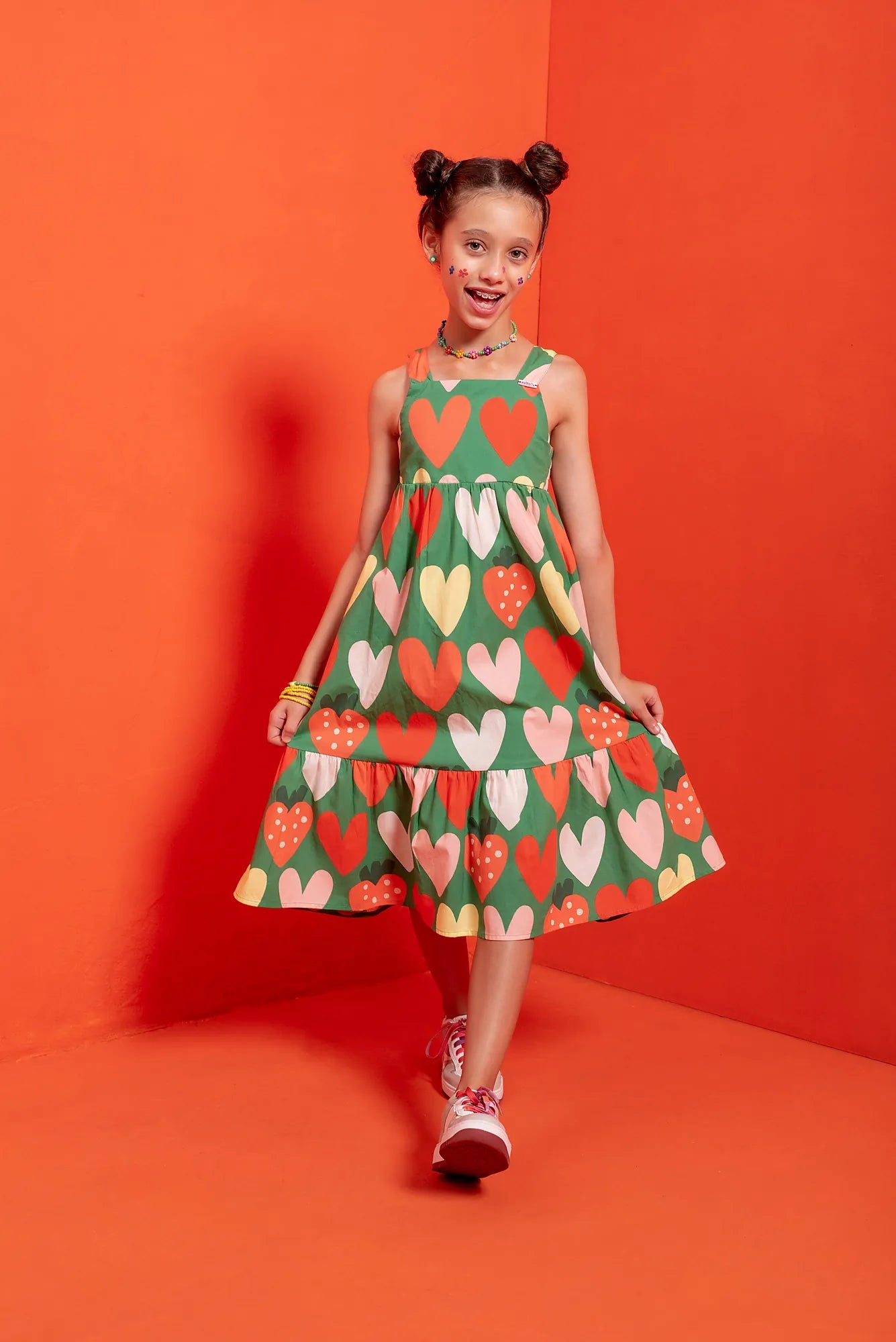 Vestido infantil verde com estampa de corações coloridos e babados na barra