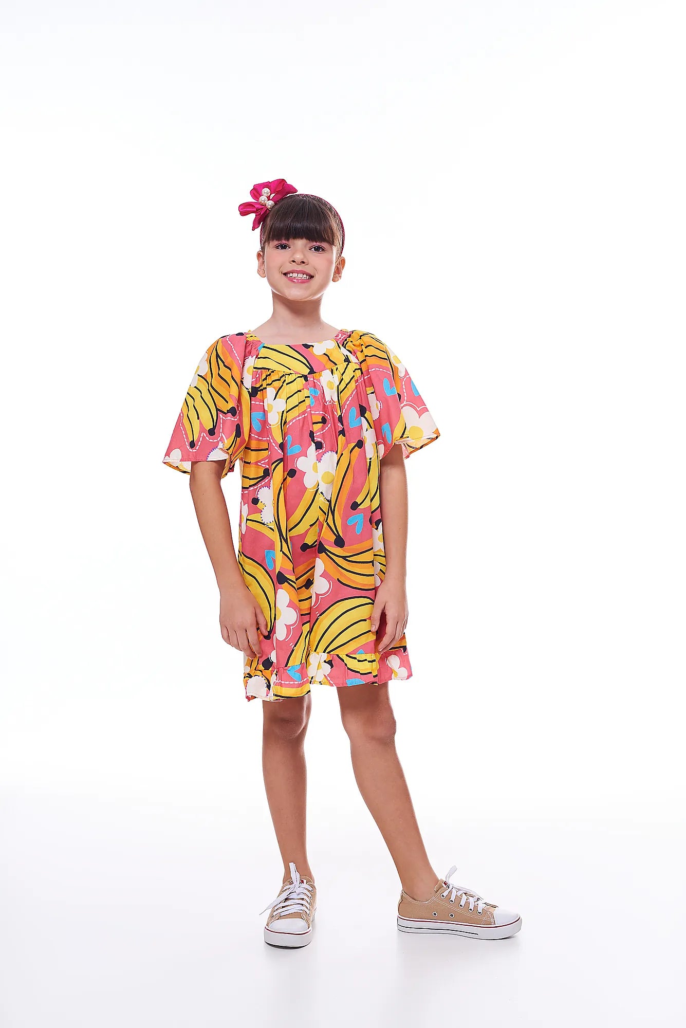 Macaco feminino infantil com estampa de bananas e flores em fundo rosa, detalhe de mangas amplas