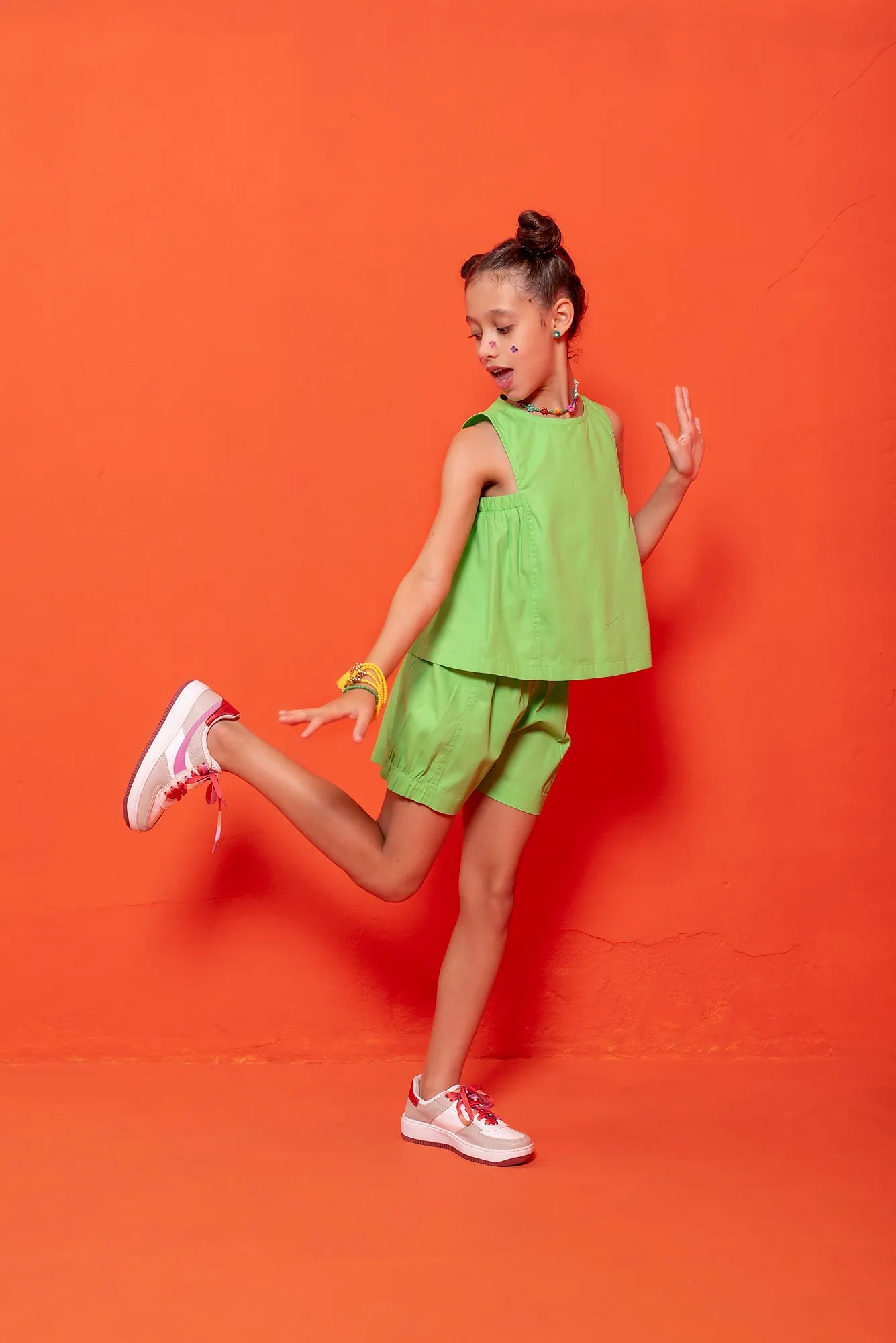 Conjunto infantil feminino com blusa verde de alças largas e short leve, ideal para brincadeiras.
