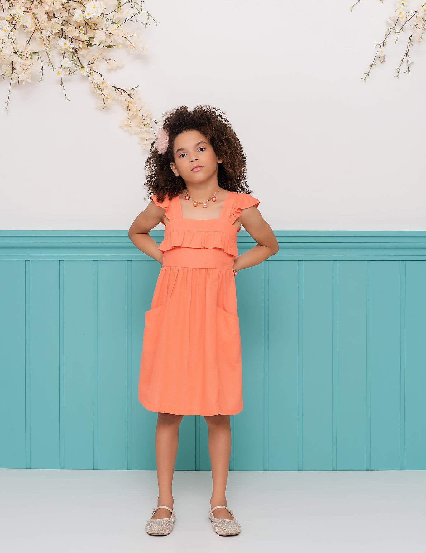 Vestido infantil com alças largas, saia solta e detalhes franzidos