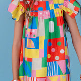 Vestido infantil com estampa de blocos coloridos e alças em babados