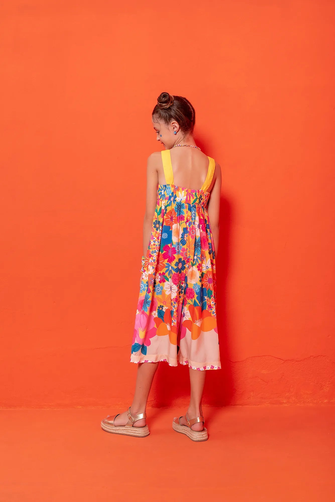 Macacão floral colorido com flores em tons vibrantes e alças largas, feminino infantil