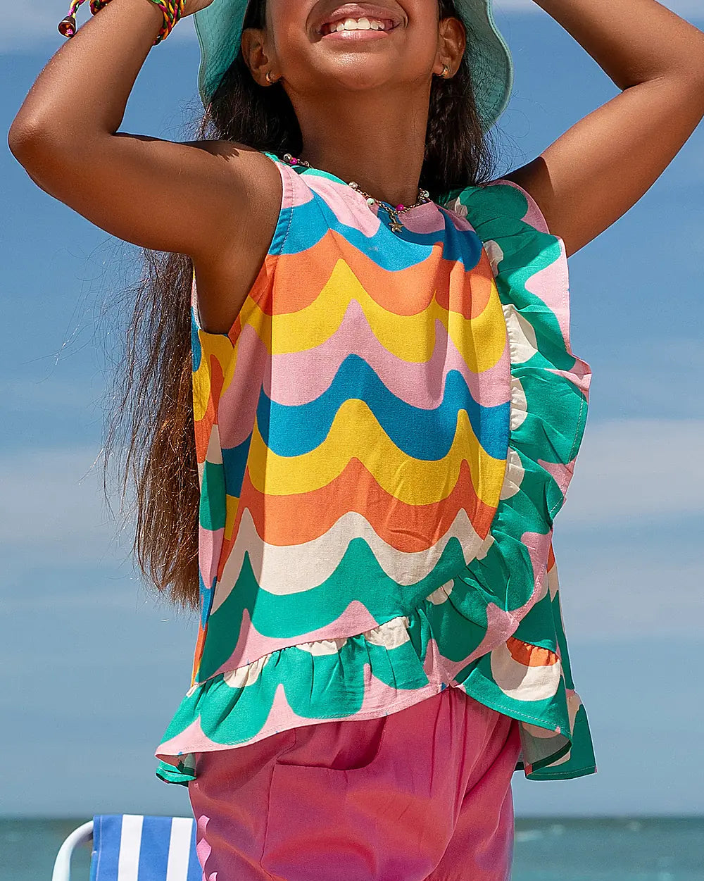 Conjunto infantil com blusa de alças largas e estampa de ondas coloridas, saia rosa