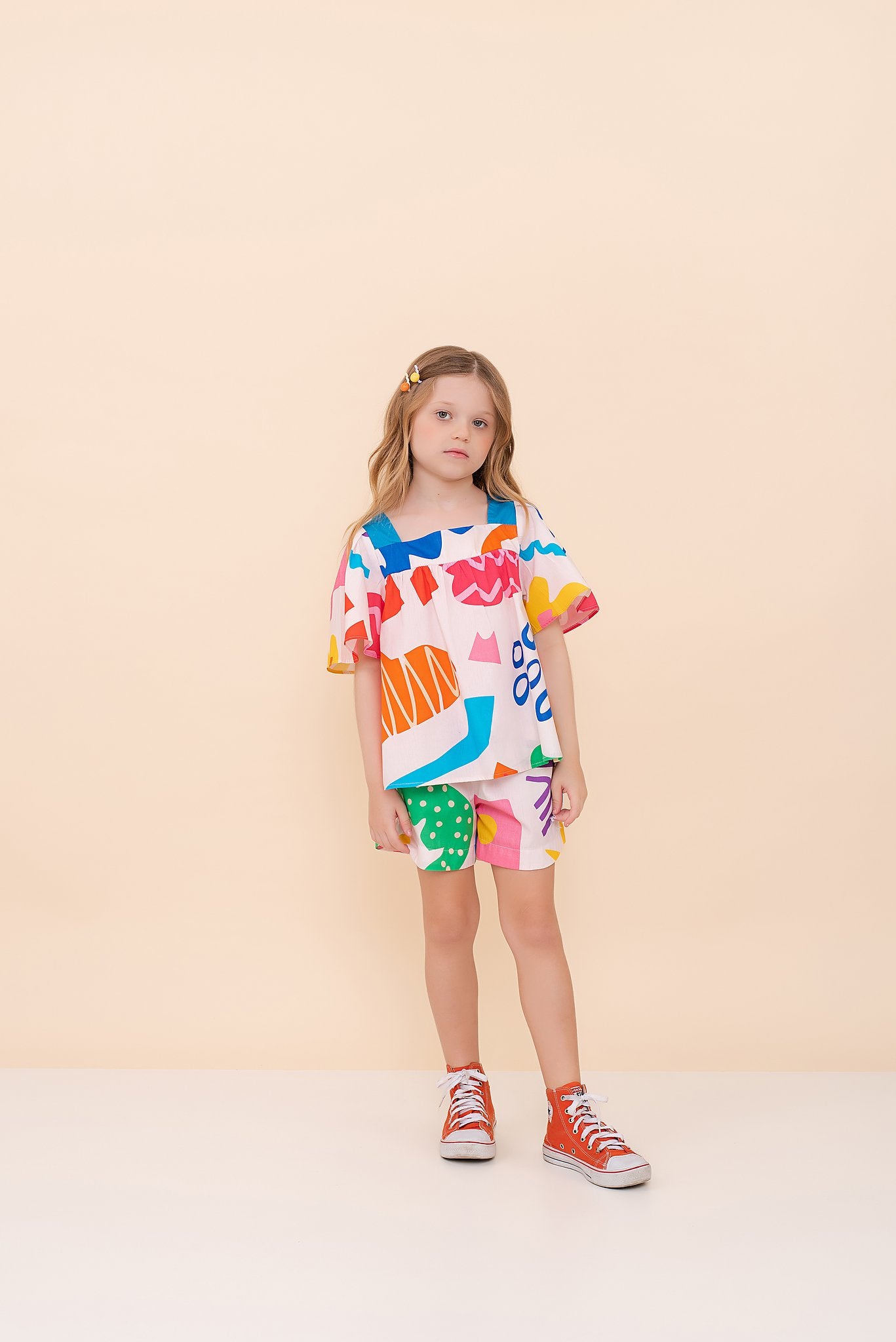 Conjunto infantil feminino com blusa de mangas amplas e shorts, estampa geométrica colorida