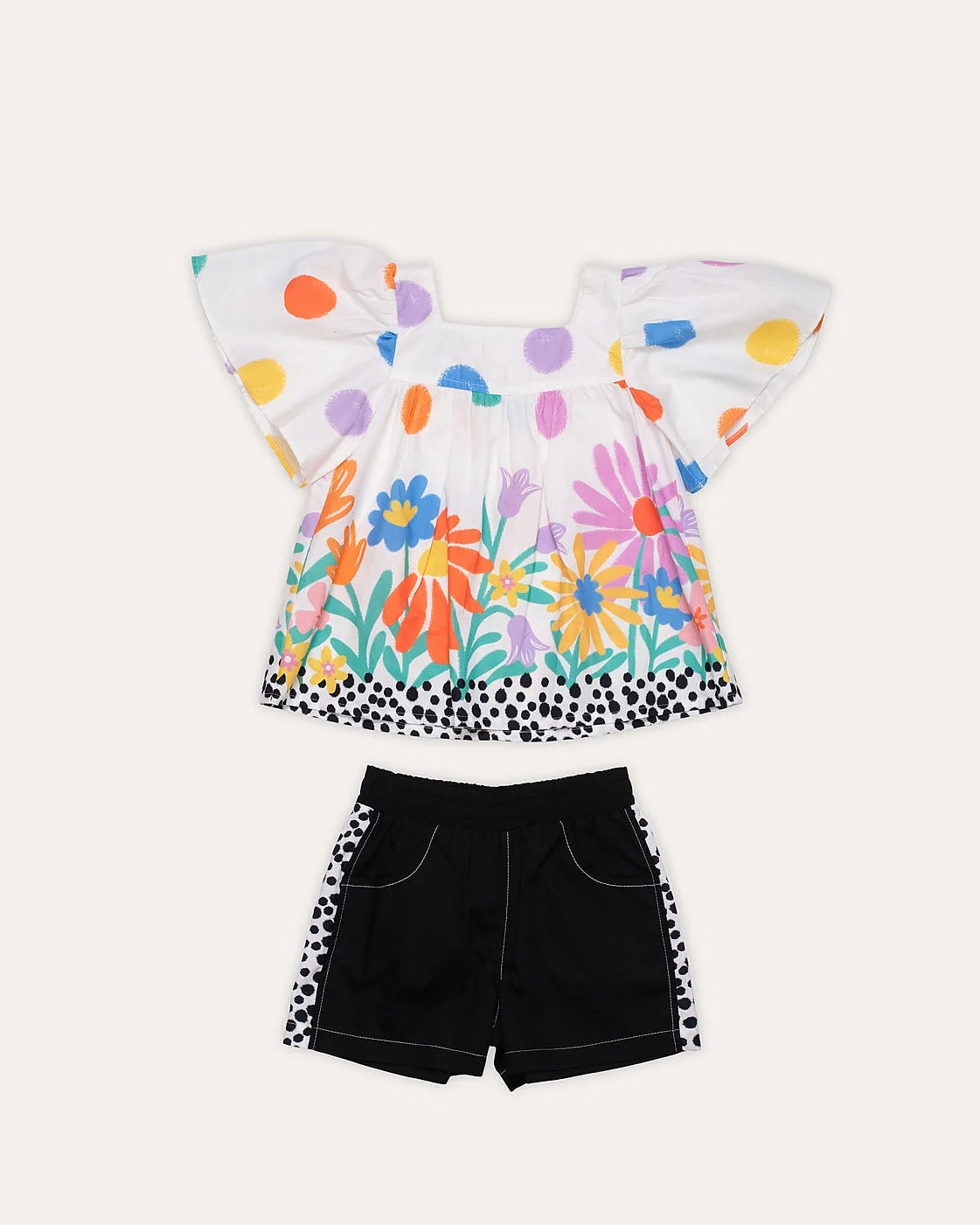Conjunto feminino infantil com blusa de mangas amplas e short preto, estampa colorida de flores e bolinhas