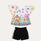 Conjunto feminino infantil com blusa de mangas amplas e short preto, estampa colorida de flores e bolinhas