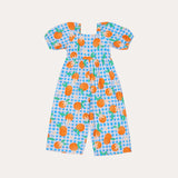 Macacão infantil com estampa de bergamotas em fundo azul xadrez e mangas bufantes