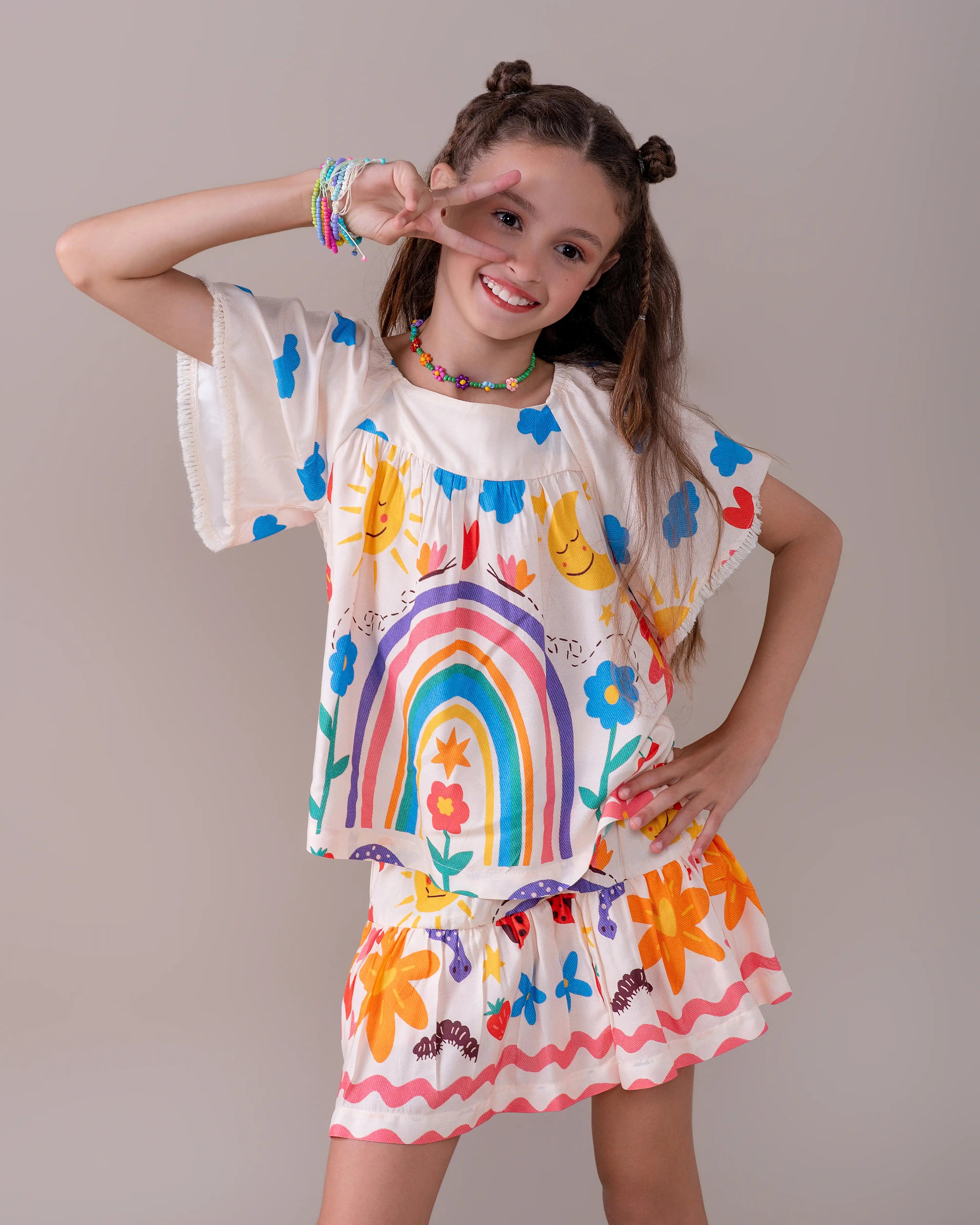 Conjunto infantil feminino com blusa de mangas bufantes e saia rodada, estampa colorida de arco-íris e flores
