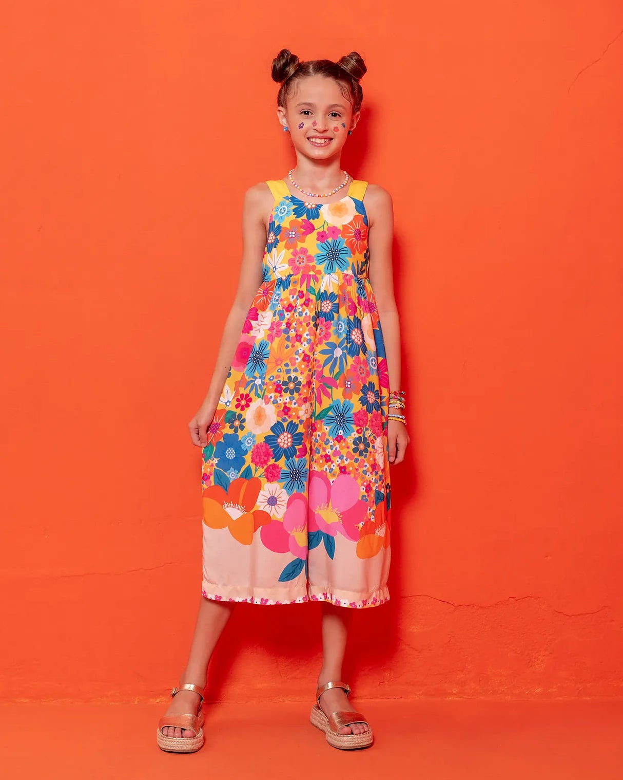 Macacão floral colorido com flores em tons vibrantes e alças largas, feminino infantil