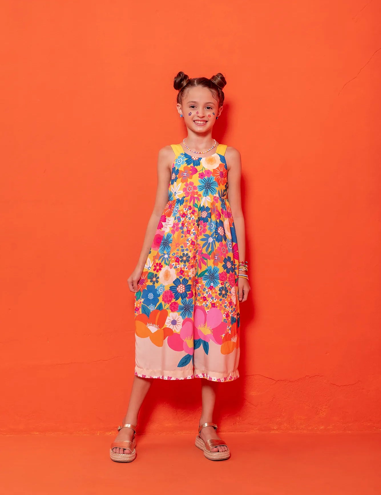 Macacão floral colorido com flores em tons vibrantes e alças largas, feminino infantil