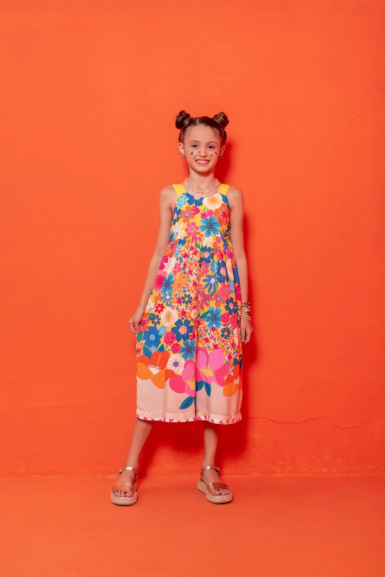 Macacão floral colorido com flores em tons vibrantes e alças largas, feminino infantil