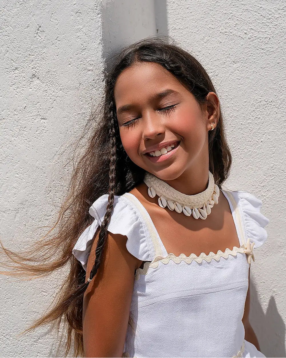 Conjunto feminino infantil com blusa de alças e saia rodada brancas, detalhes em babados