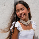 Conjunto feminino infantil com blusa de alças e saia rodada brancas, detalhes em babados