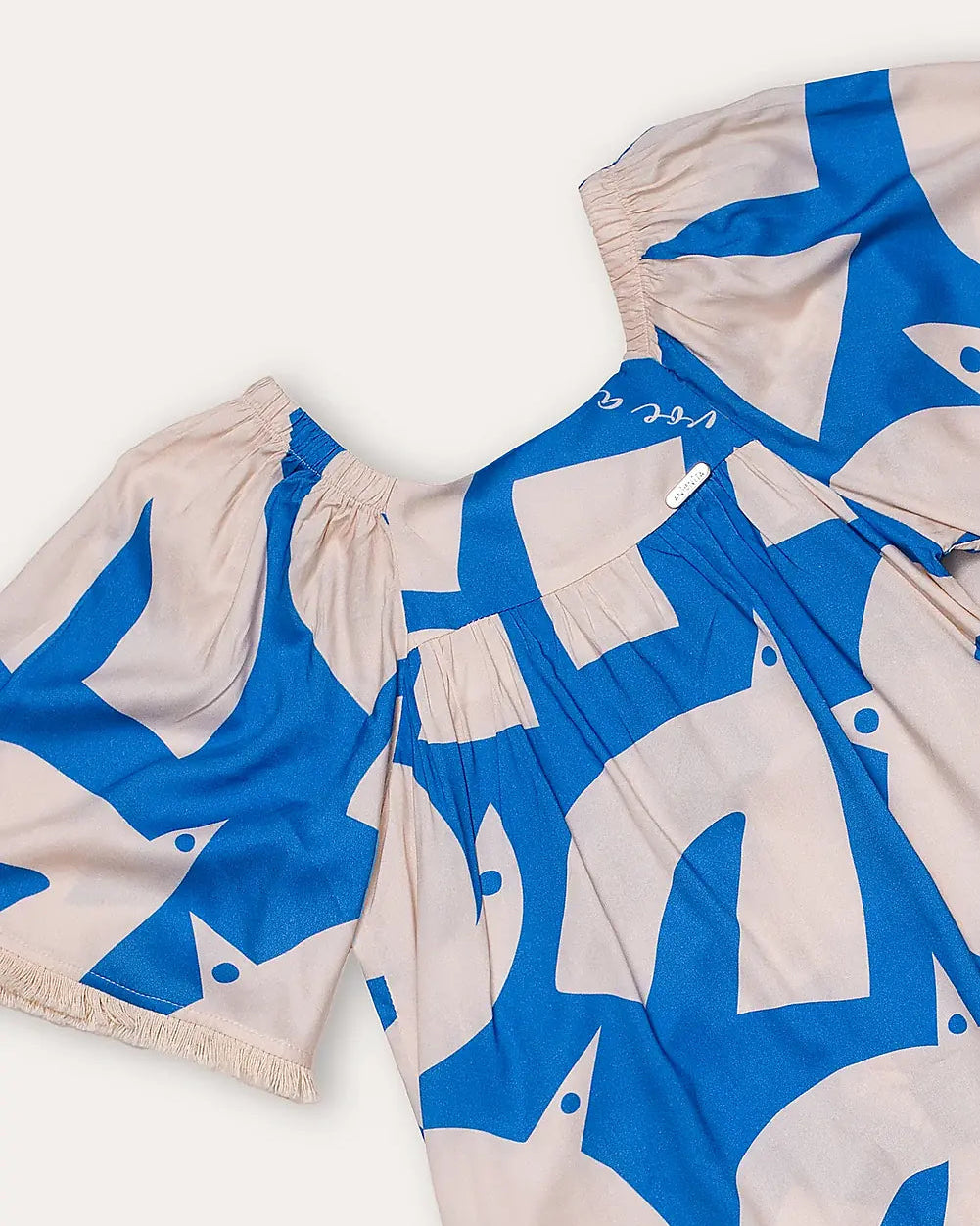 Vestido infantil com estampa geométrica em azul e creme, mangas amplas e gola arredondada