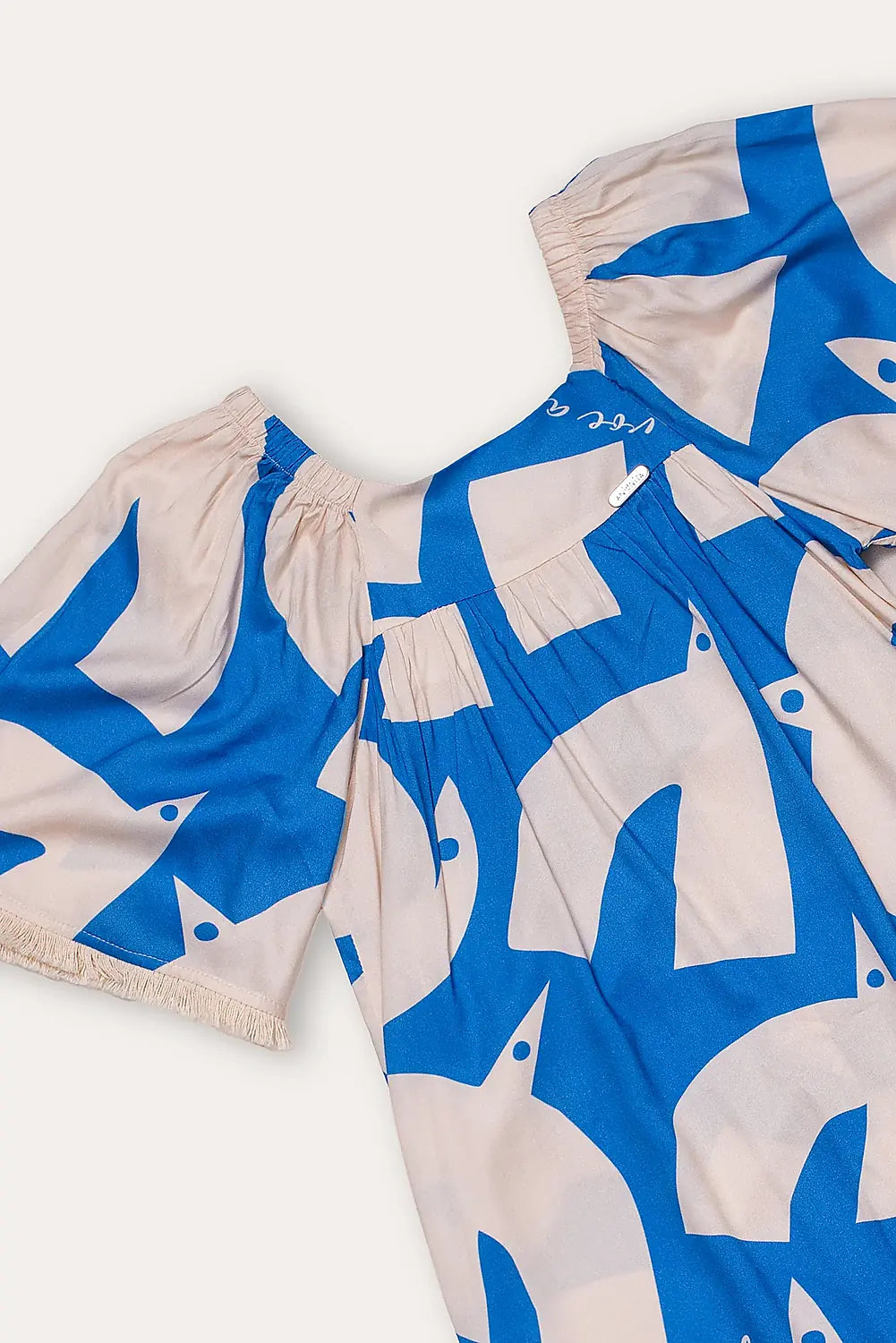 Vestido infantil com estampa geométrica em azul e creme, mangas amplas e gola arredondada