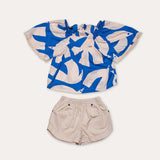 Conjunto feminino infantil com blusa de mangas amplas estampada em azul e branco e short claro