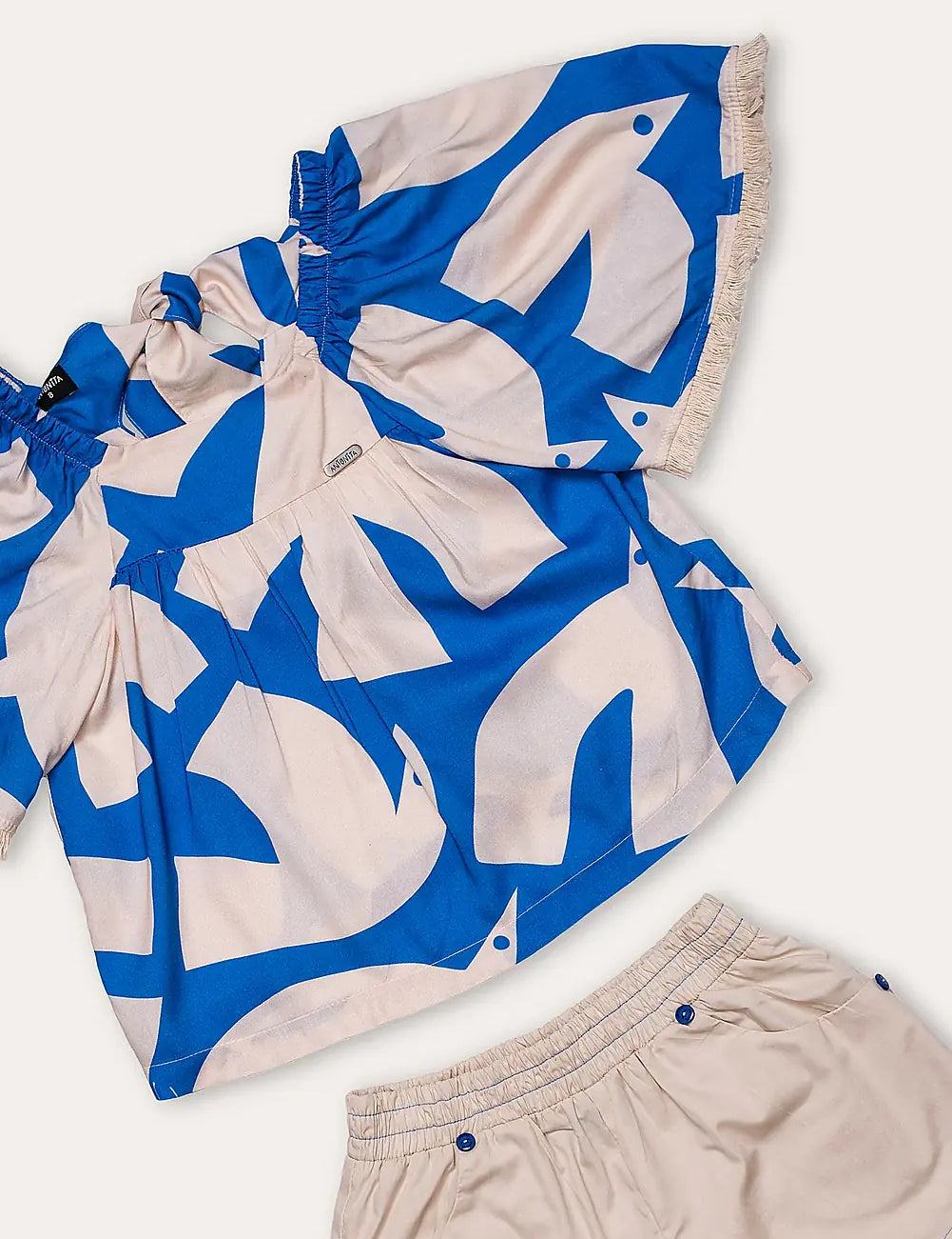 Conjunto feminino infantil com blusa de mangas amplas estampada em azul e branco e short claro