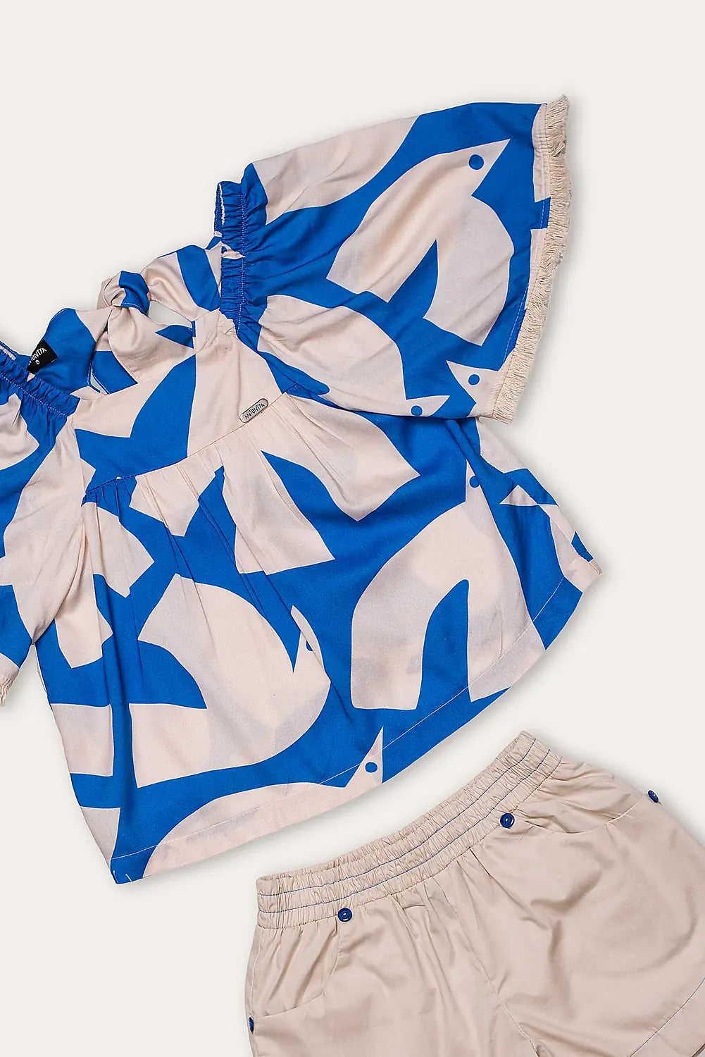 Conjunto feminino infantil com blusa de mangas amplas estampada em azul e branco e short claro