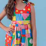 Macacão infantil feminino com estampa geométrica colorida e alças amarradas