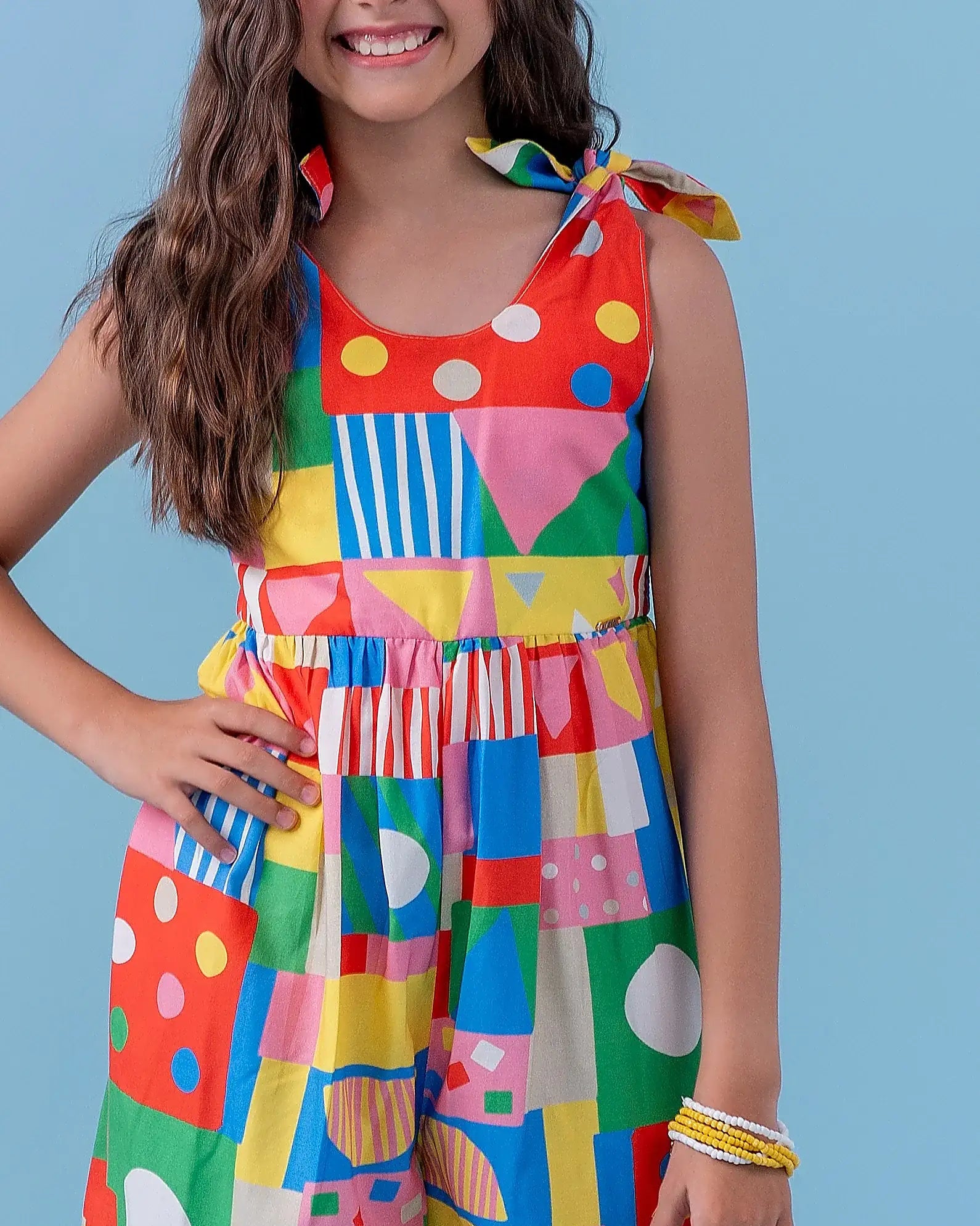 Macacão infantil feminino com estampa geométrica colorida e alças amarradas