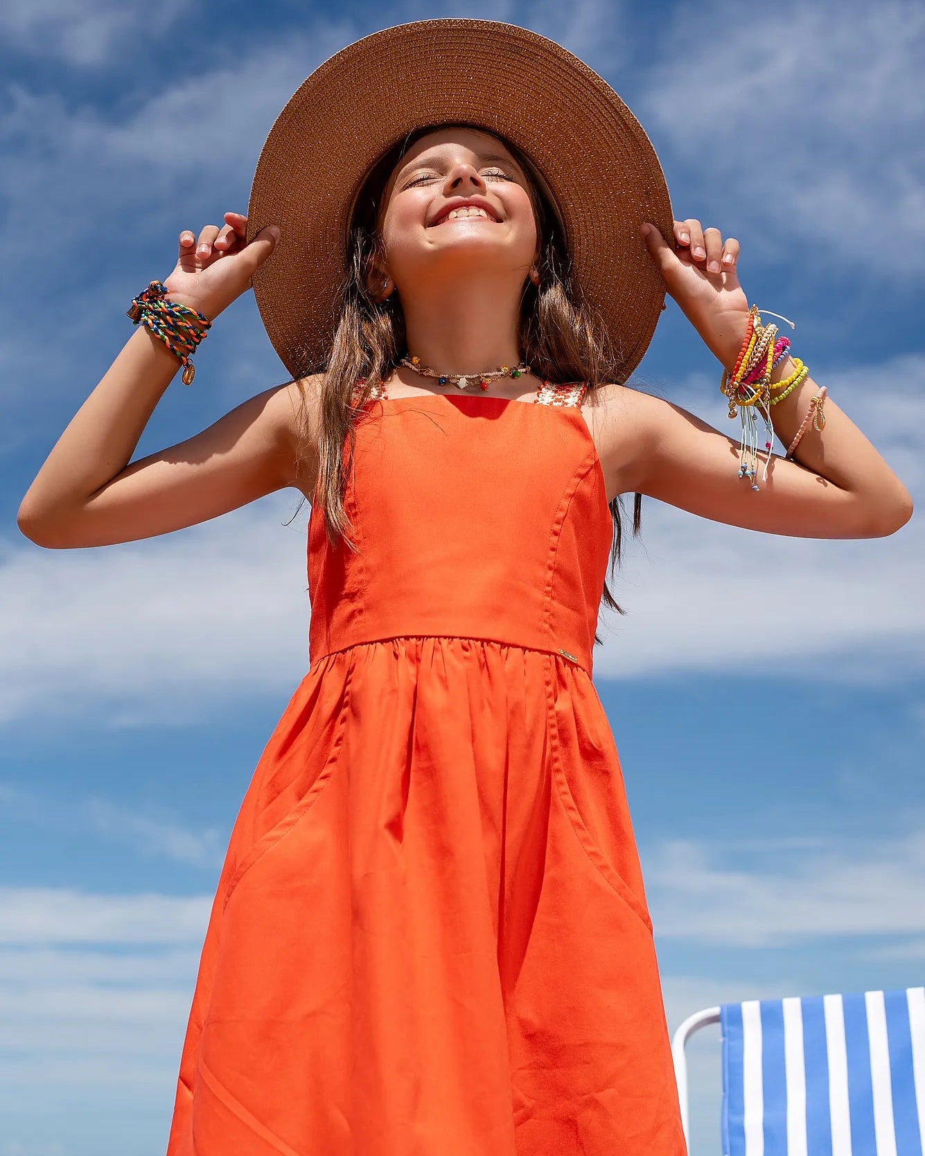 Vestido infantil vermelho com alças finas e saia ampla, detalhe de costura nas alças
