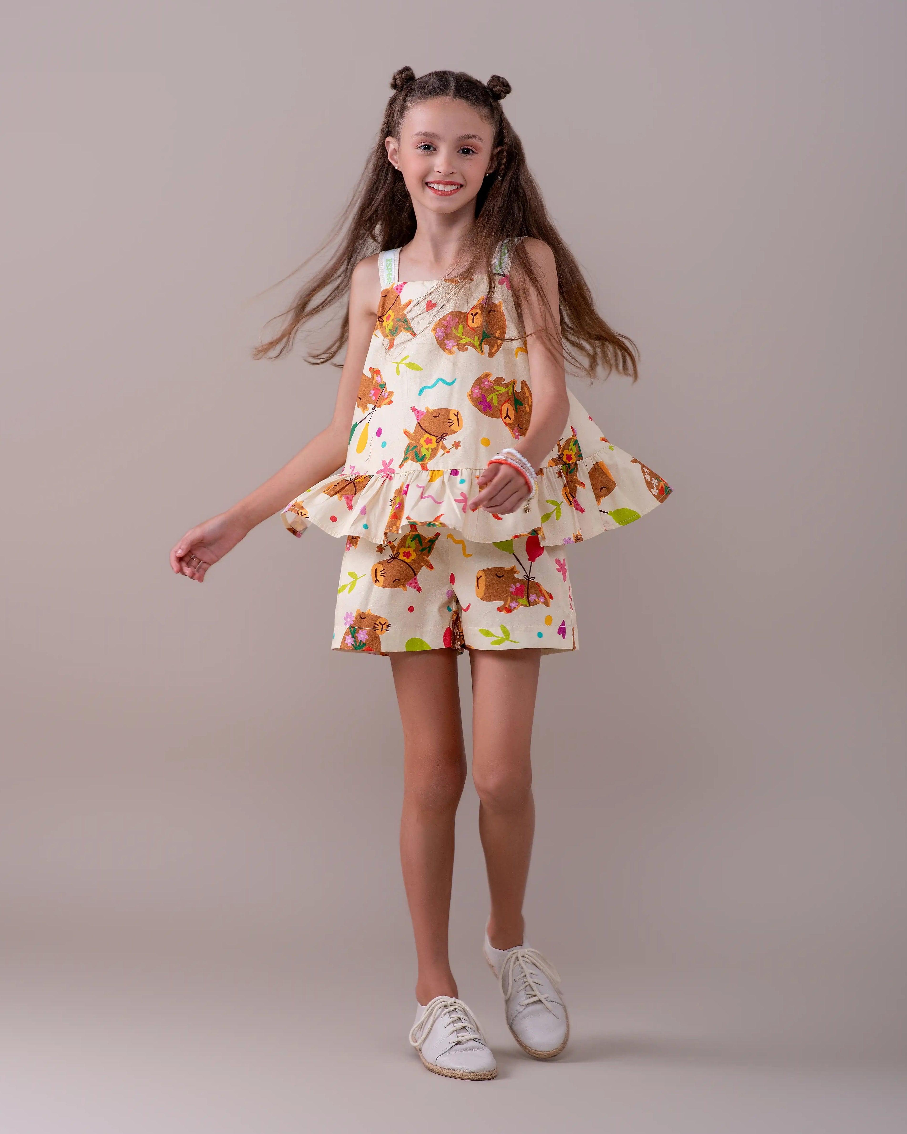 Macacão infantil com estampa de capivaras e flores, alças largas e camadas na parte inferior