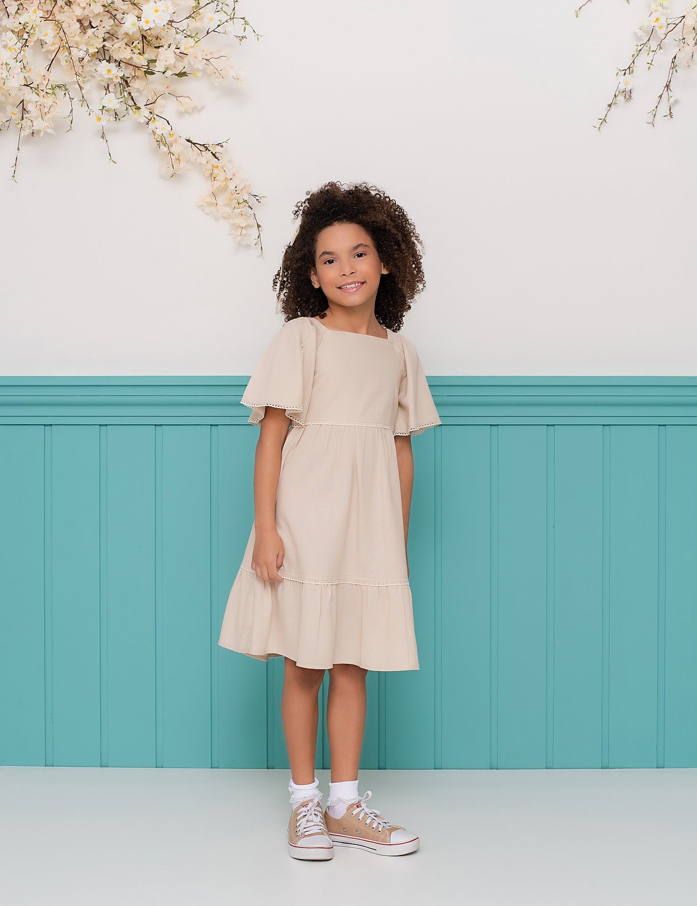 Vestido infantil com mangas amplas e saia rodada em tom neutro