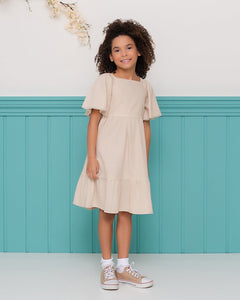 Vestido infantil com mangas amplas e saia rodada em tom neutro