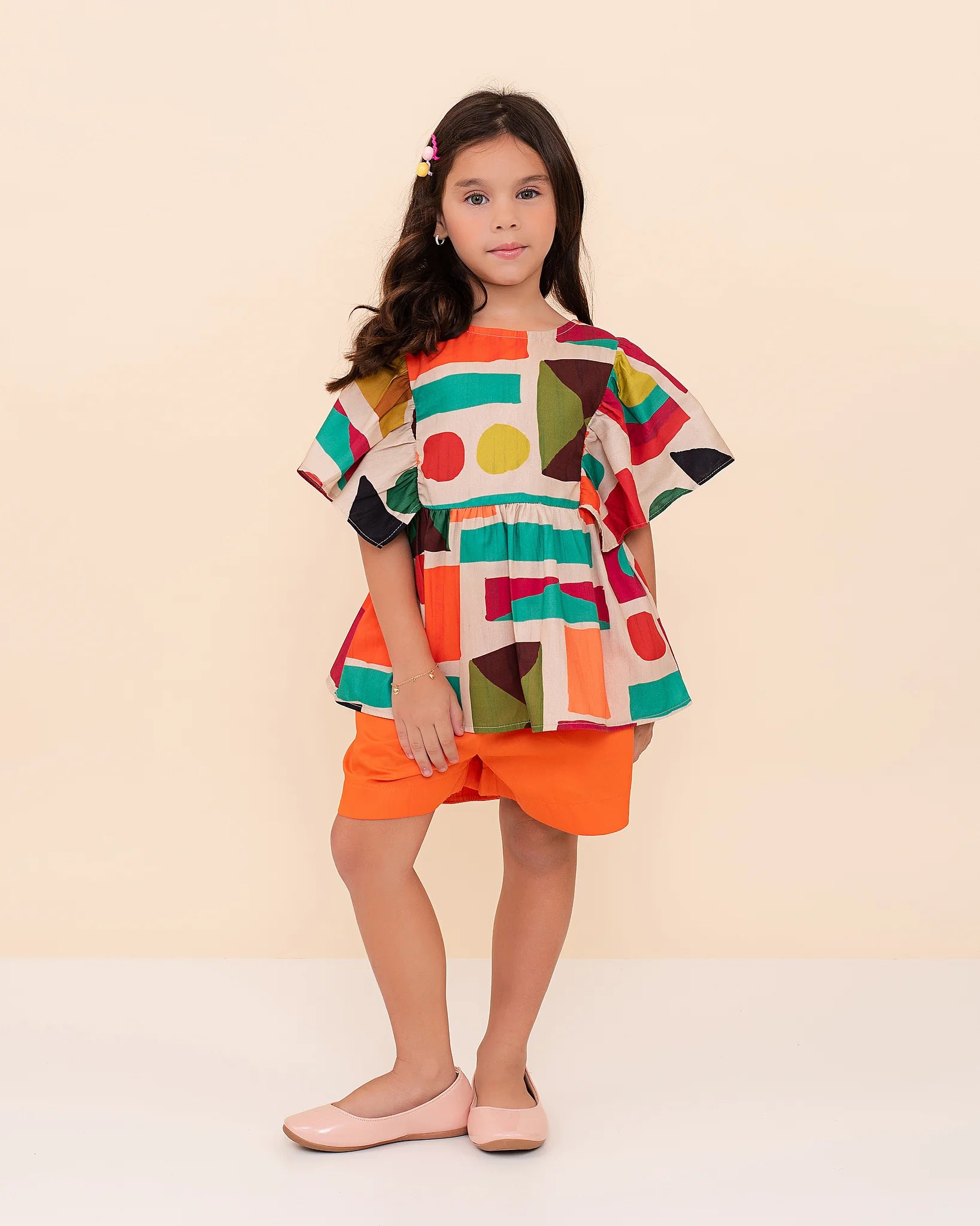 Conjunto feminino infantil com blusa estampada em formas geométricas e short laranja