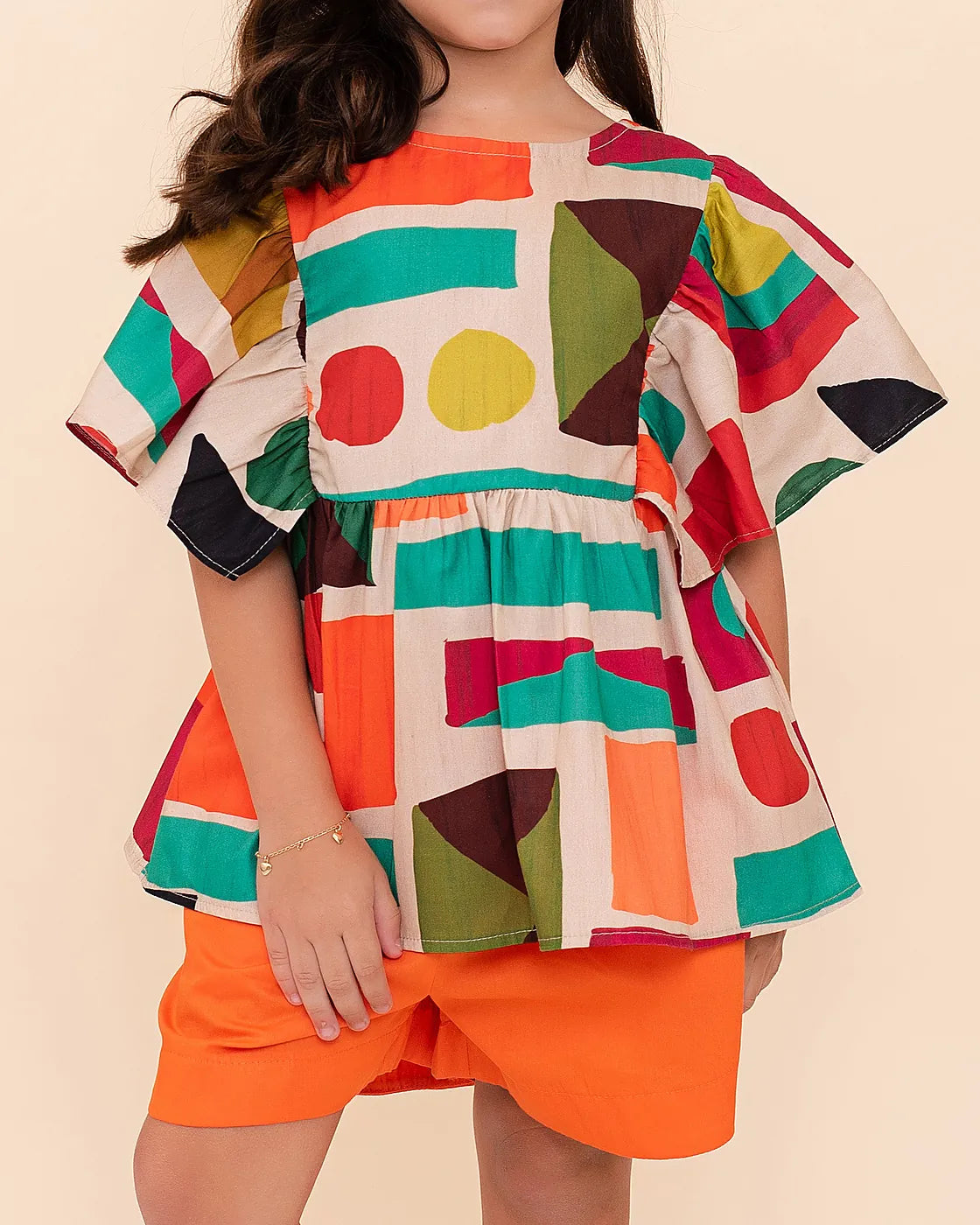 Conjunto feminino infantil com blusa estampada em formas geométricas e short laranja
