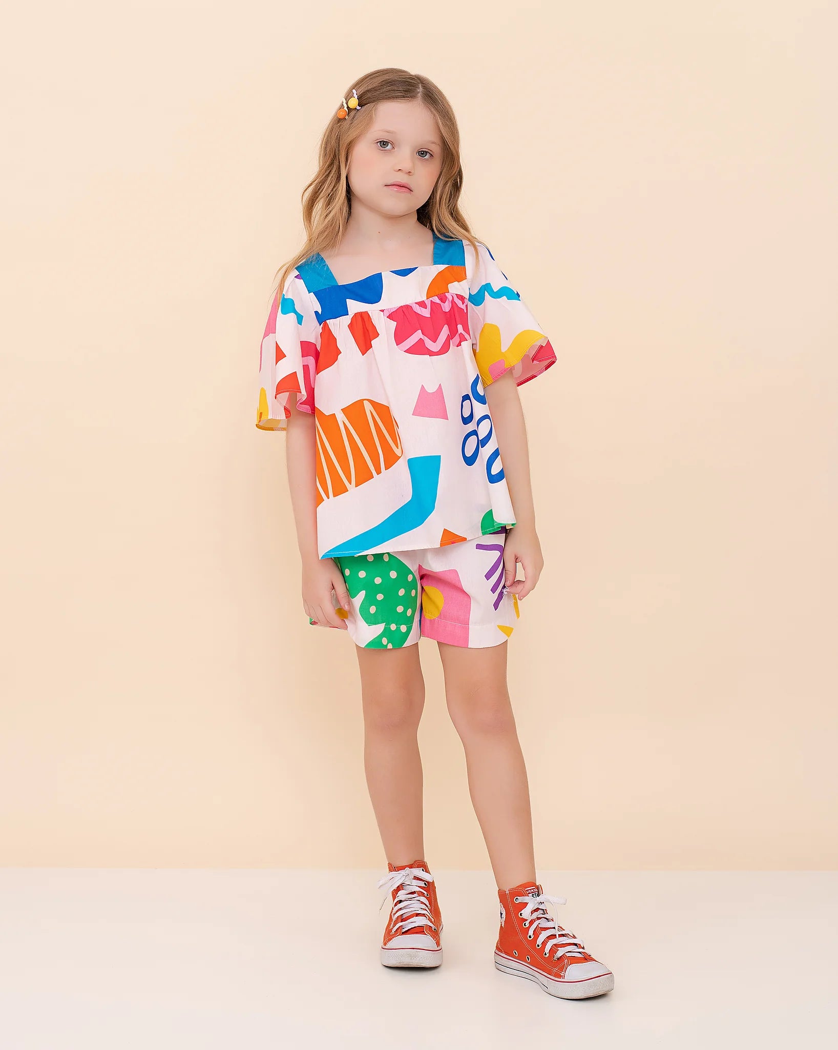 Conjunto infantil feminino com blusa de mangas amplas e shorts, estampa geométrica colorida