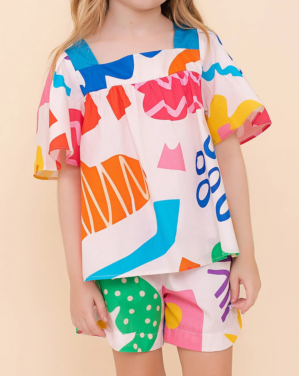 Conjunto infantil feminino com blusa de mangas amplas e shorts, estampa geométrica colorida