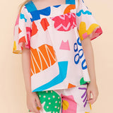 Conjunto infantil feminino com blusa de mangas amplas e shorts, estampa geométrica colorida
