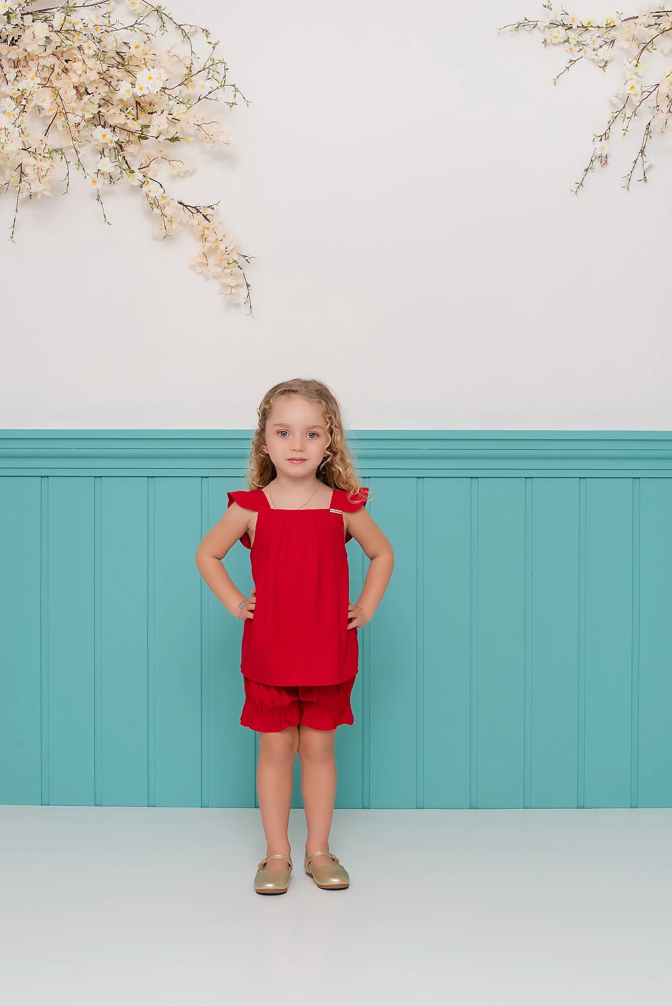 Conjunto infantil feminino com blusa vermelha de alças e short leve, detalhes em babados