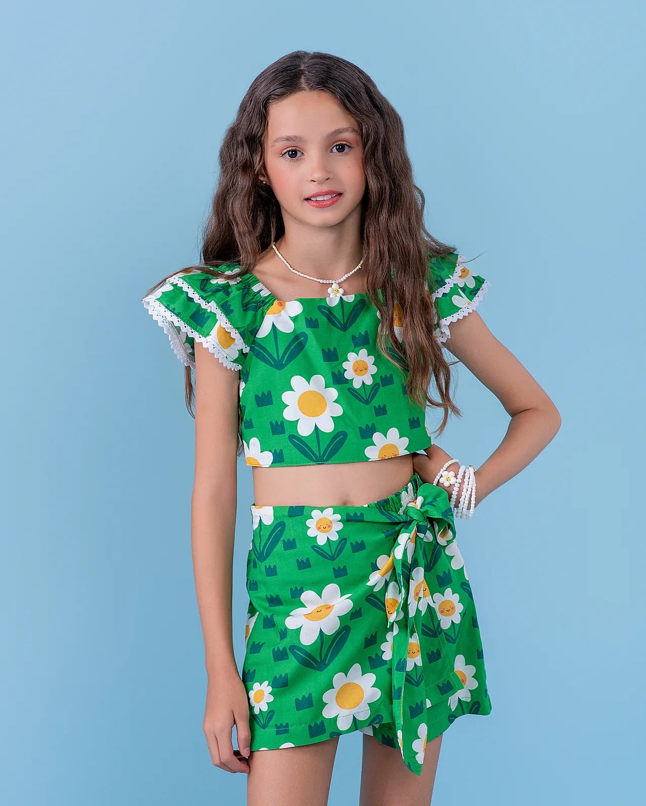 Conjunto infantil feminino com blusa cropped e short floral verde, detalhes em babado e estampa de flores amarelas