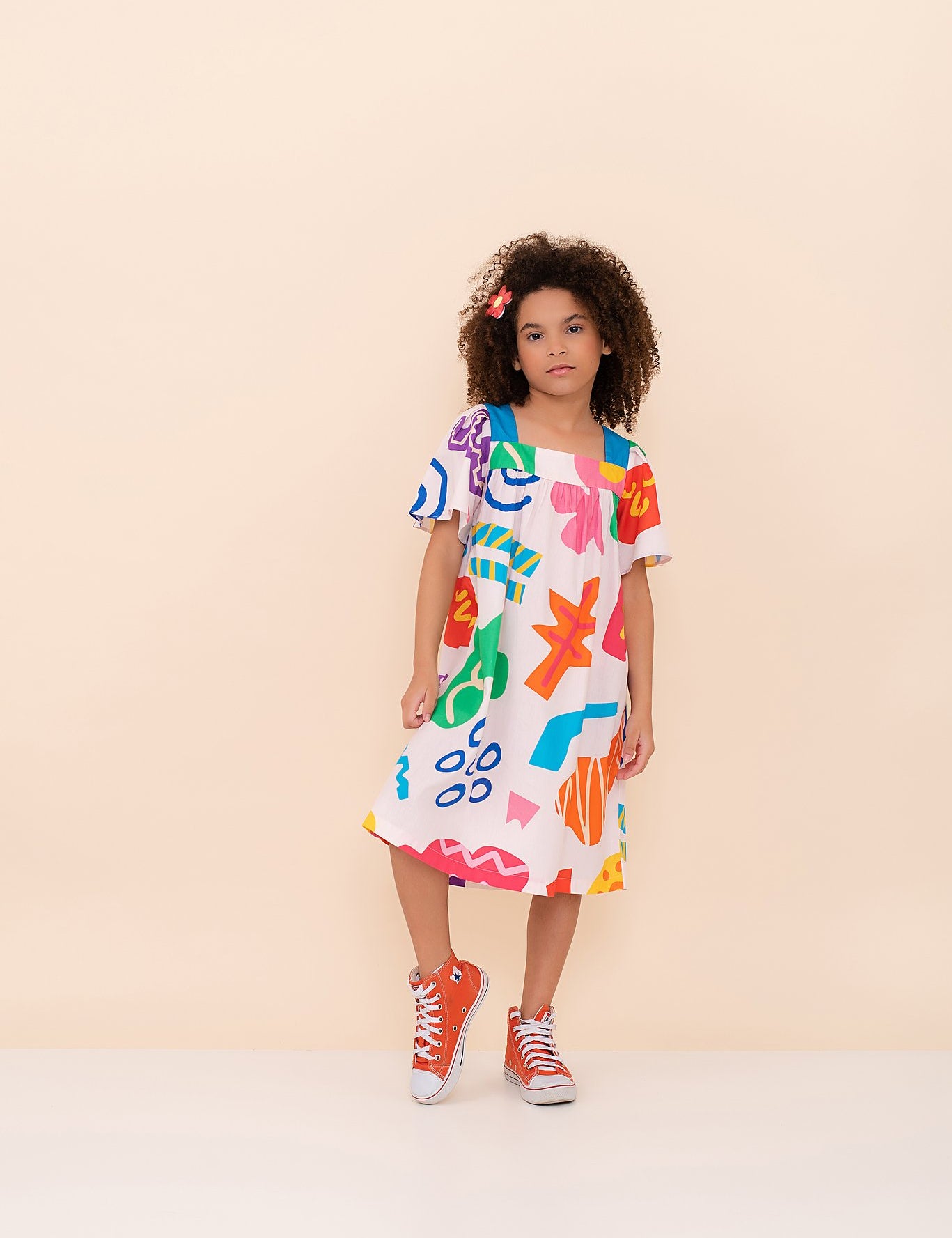 Vestido infantil com estampa colorida de formas geométricas e mangas amplas