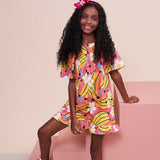 Macaco feminino infantil com estampa de bananas e flores em fundo rosa, detalhe de mangas amplas