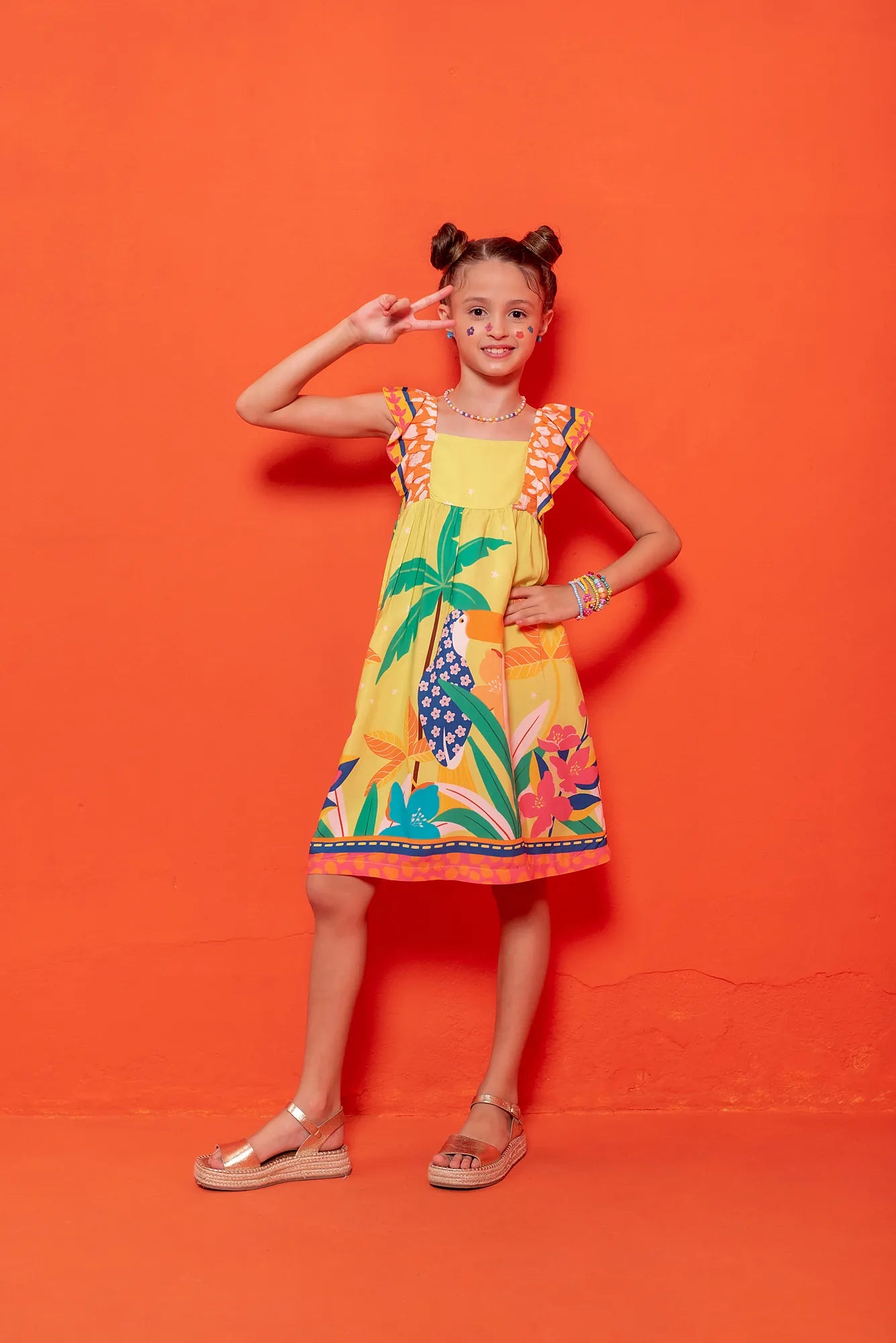 Vestido infantil com estampa tropical de flores e folhas coloridas, alças largas listradas