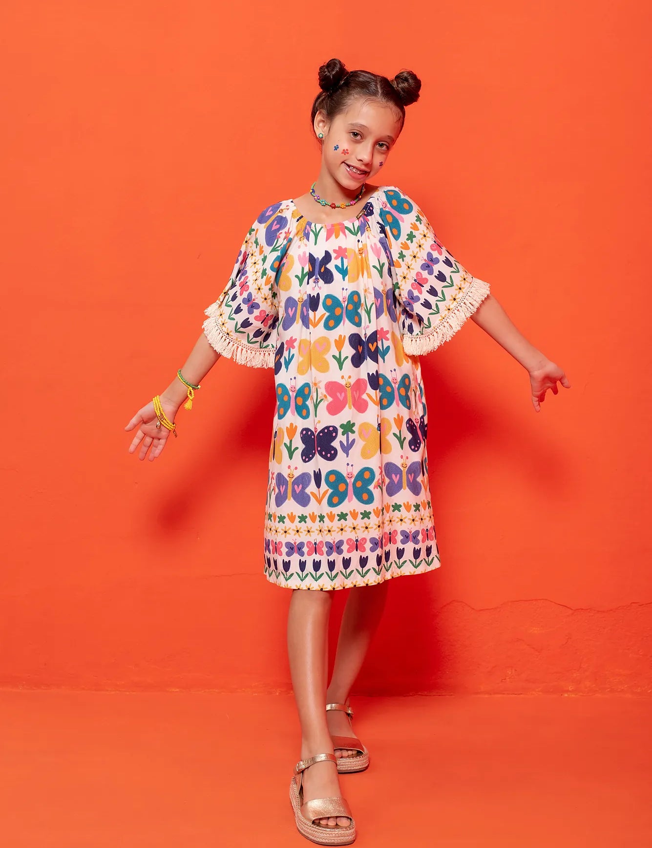 Vestido midi infantil com estampa de borboletas coloridas e franjas na barra
