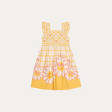 Vestido infantil amarelo com estampa floral e alças largas, detalhe em babados na barra