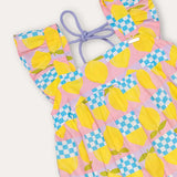 Vestido infantil amarelo com estampa de círculos e quadrados coloridos, alças largas e saia rodada