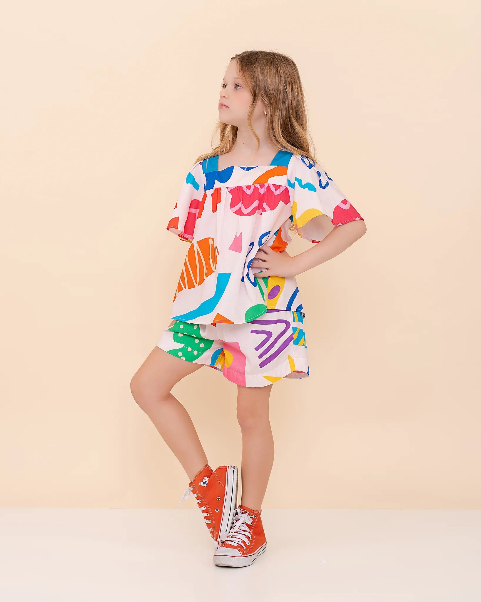 Conjunto infantil feminino com blusa de mangas amplas e shorts, estampa geométrica colorida