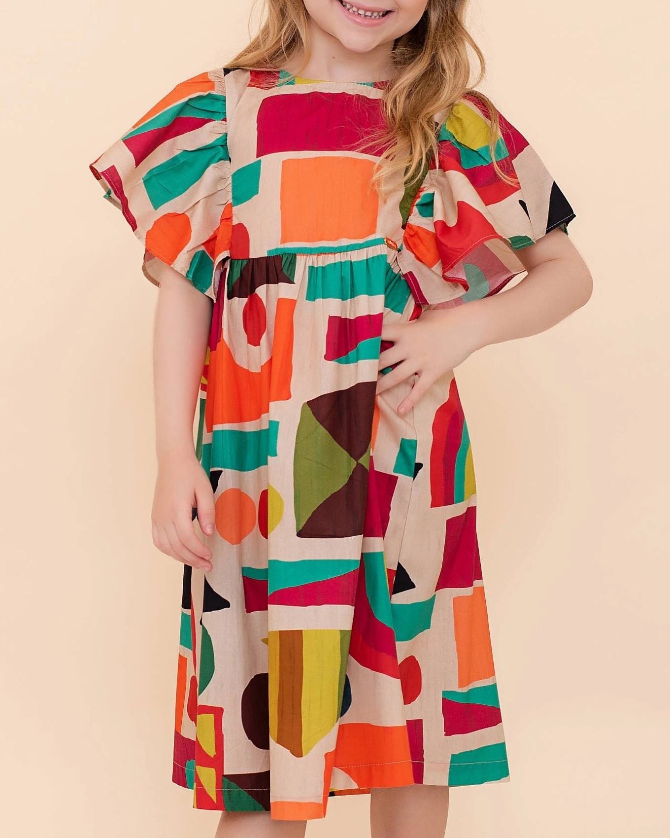 Vestido infantil com estampa geométrica colorida e mangas bufantes, ideal para meninas.