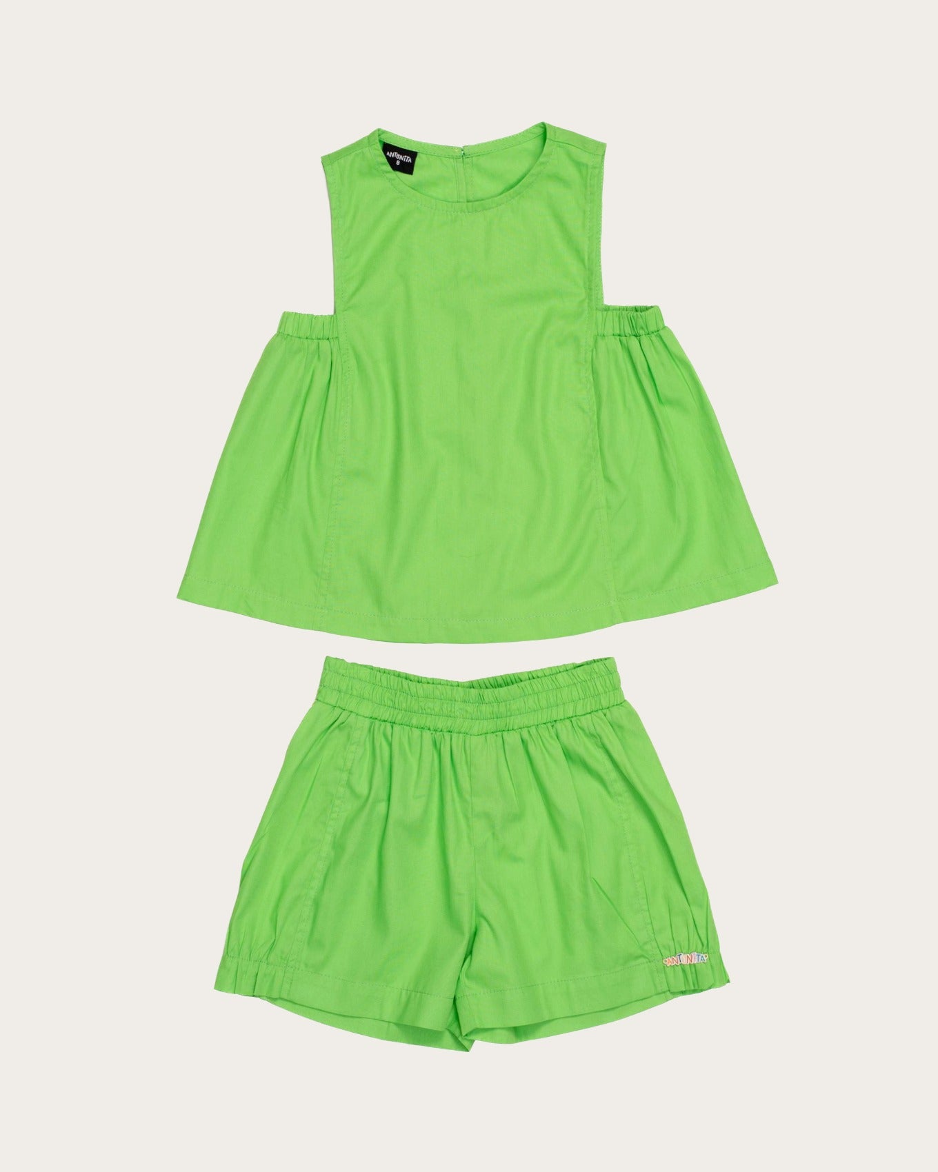 Conjunto infantil feminino com blusa verde de alças largas e short leve, ideal para brincadeiras.