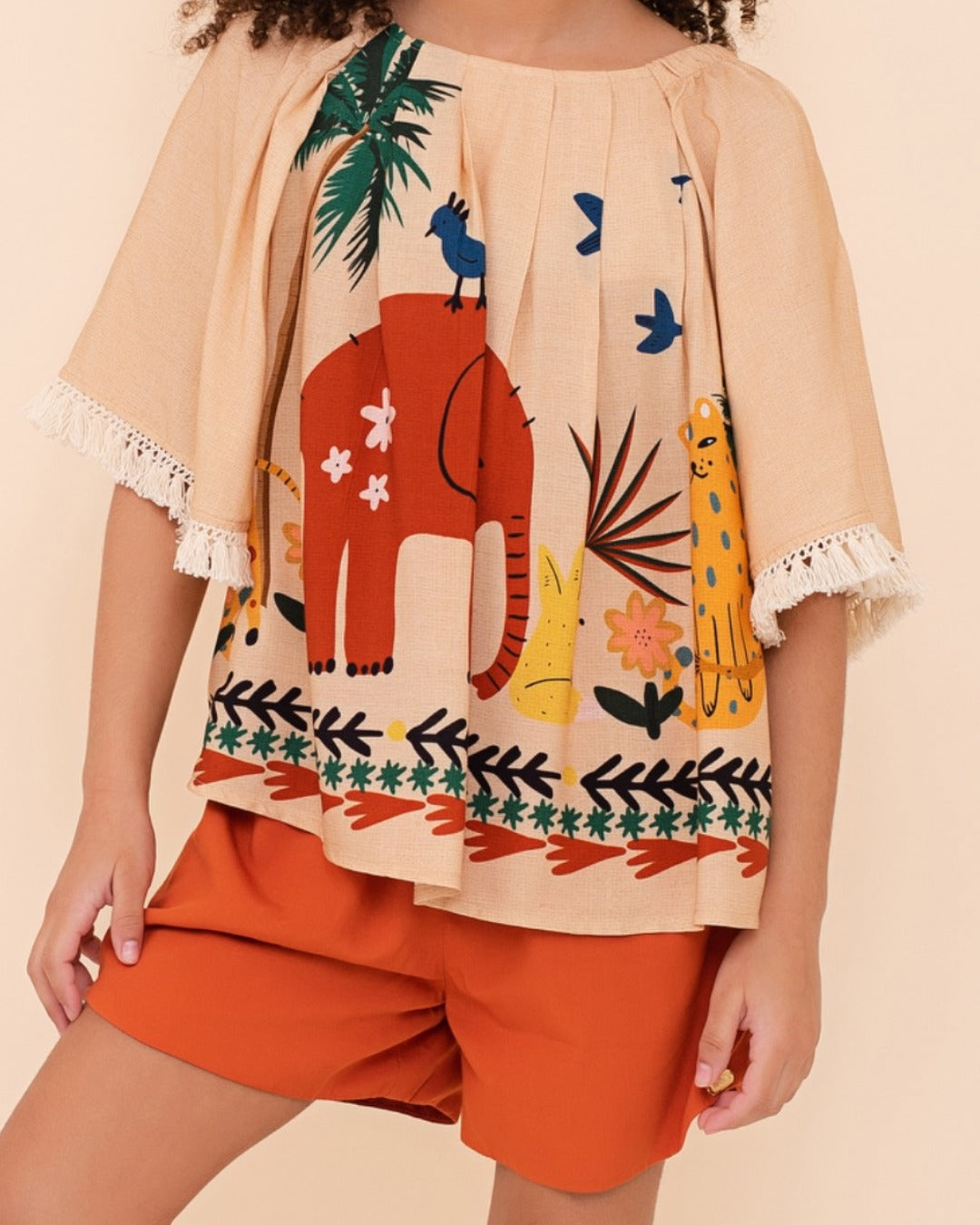Conjunto infantil com blusa de mangas amplas e shorts laranja, estampa de elefante e natureza